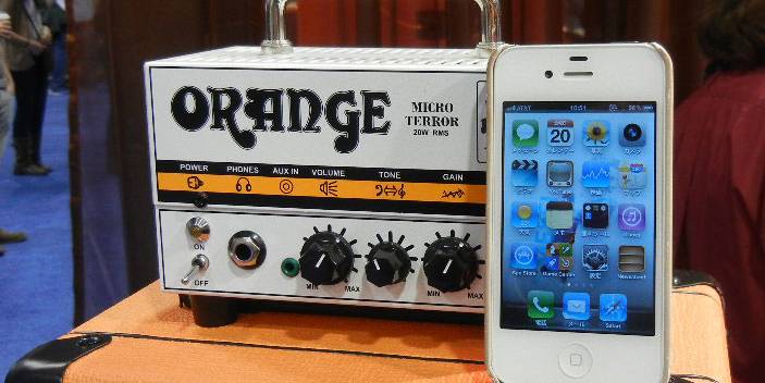 Orange Micro Terror Next To An Iphone
