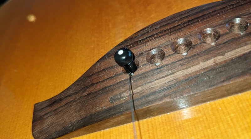 How to Restring an Acoustic Guitar - put ball end of string into bridge